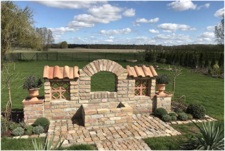 Gartenbrunnen mit Kulisse, gebaut mit handgestrichenen Vollziegeln und Formziegel "Blume". • Kundenfoto